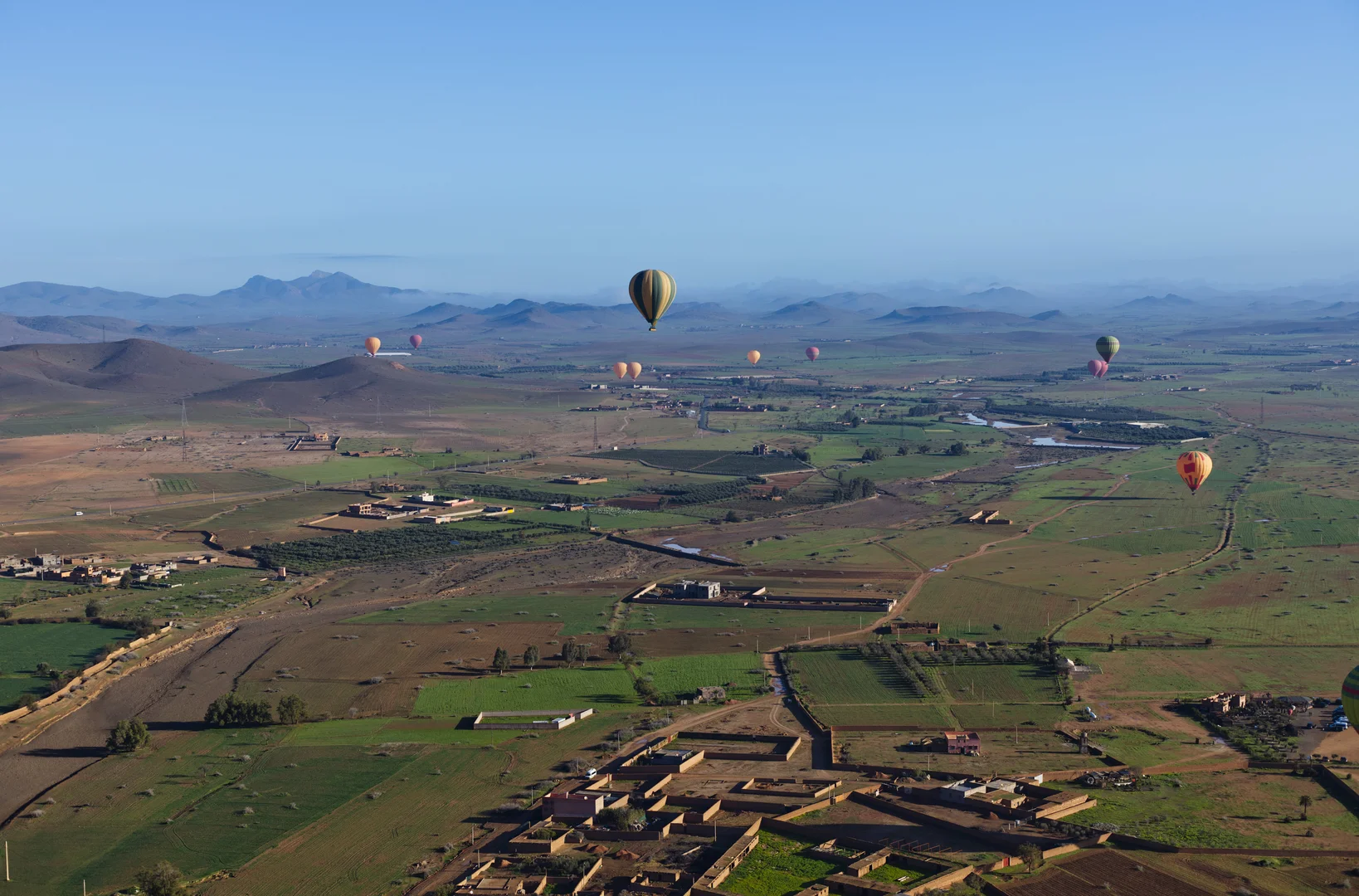 Luchtballon zweeft boven de vlakte van Marrakech op een heldere ochtend